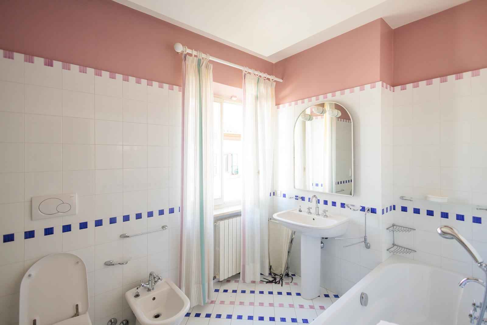 Bagno blu cobalto con doppio lavabo, specchio dorato e vasca da bagno