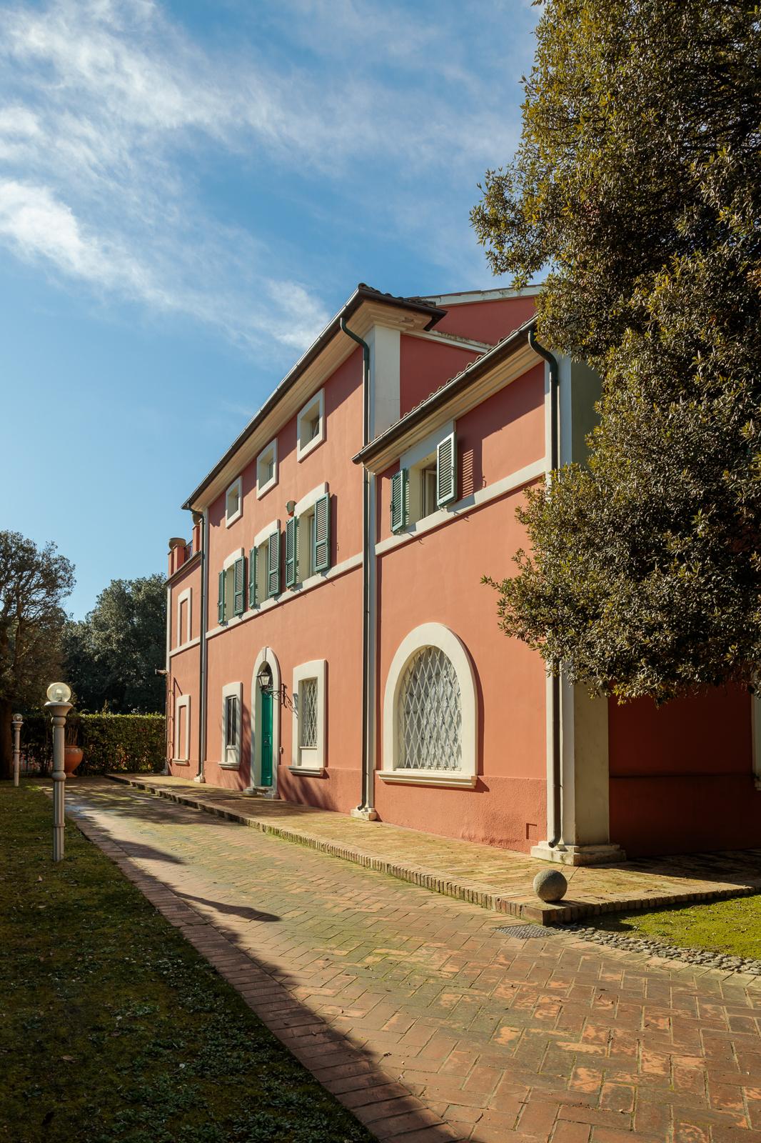 Giardino della villa con viale alberato e geometrie sempreverdi