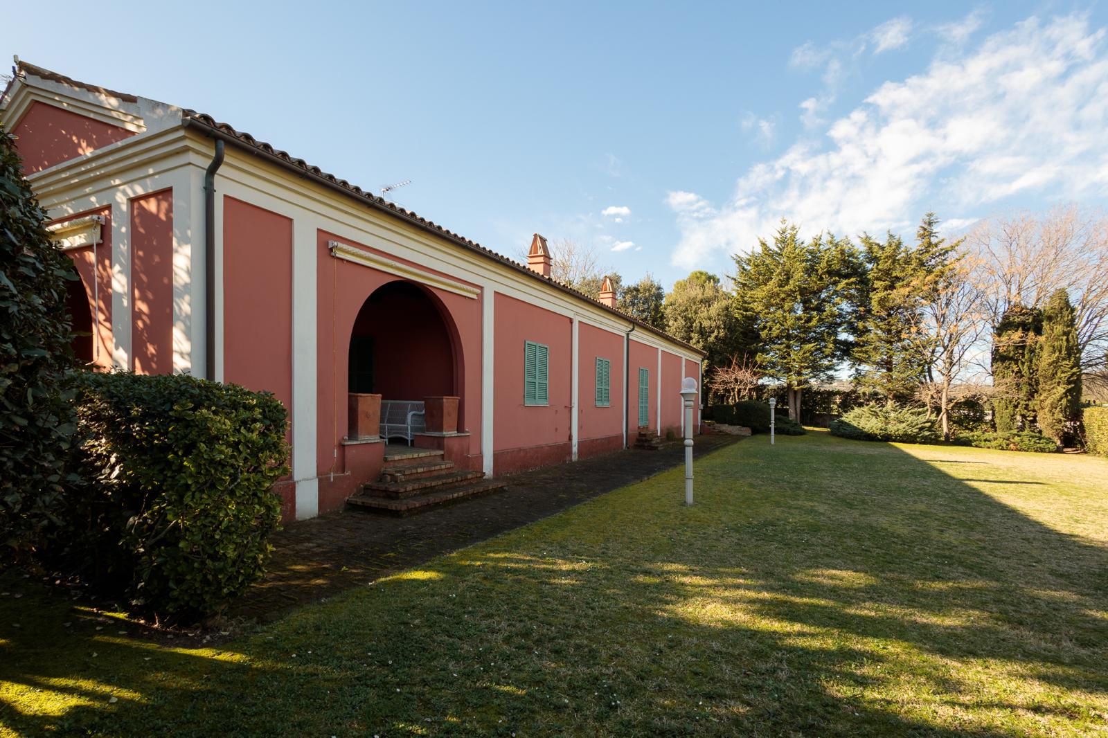 Giardino all'italiana con viale alberato e geometrie sempreverdi