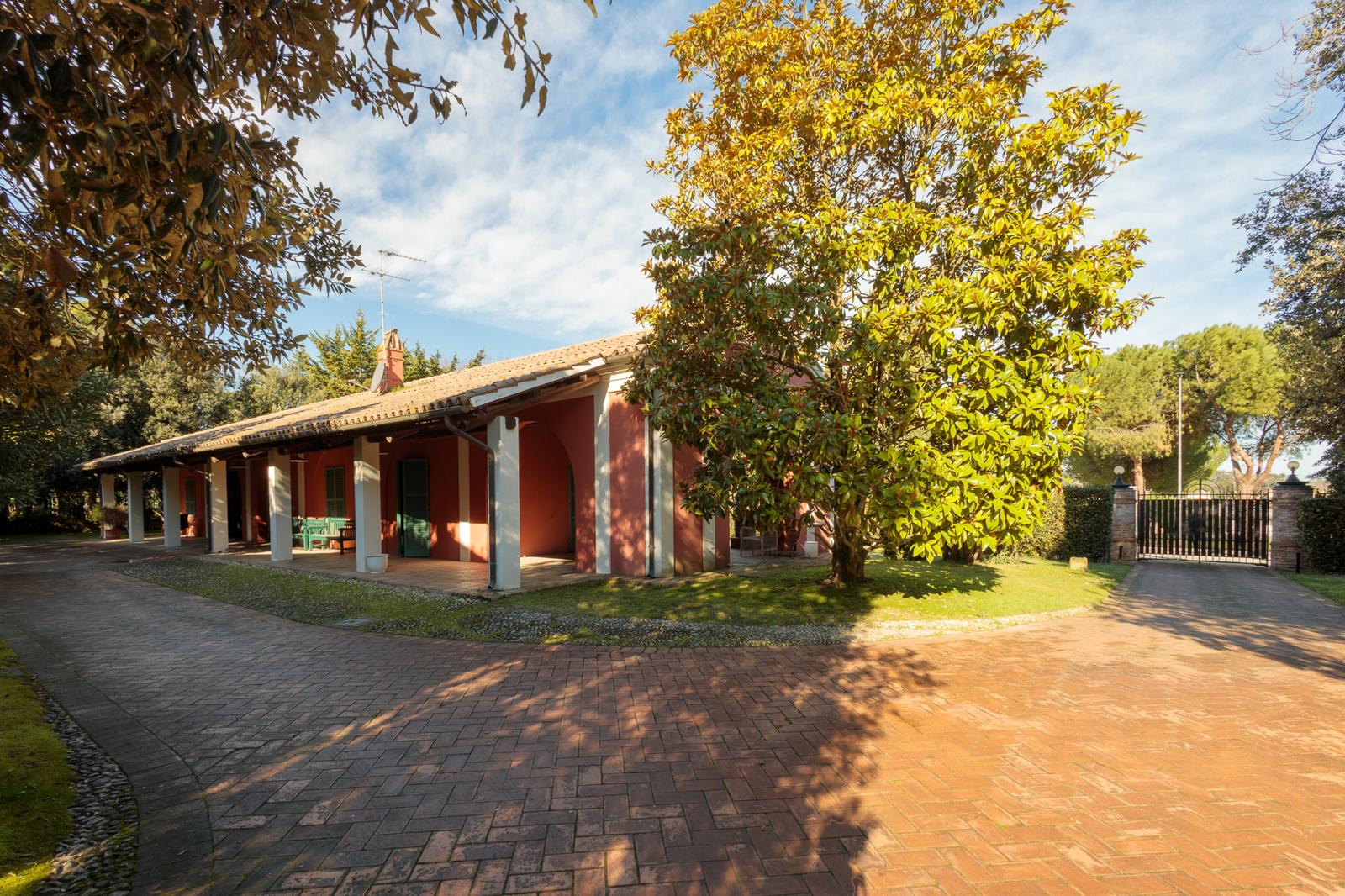 Giardino laterale della villa con vegetazione rigogliosa