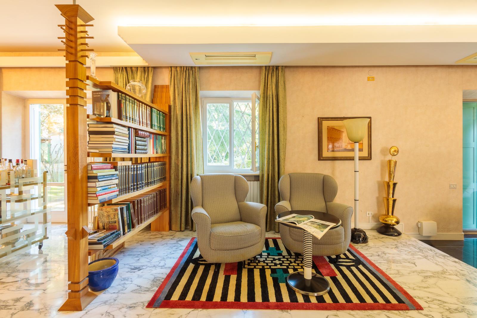Salone con dettagli scenografici e capitelli colorati di Serafini